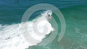 Aerial shot: male surfer catches and ride a massive barreling waves. Drone tracking footage of a surfer balancing on a