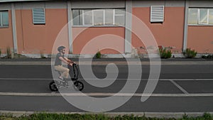 Aerial shot : Man rides his foldable electric bike on the street