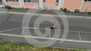 Aerial shot : Man rides his foldable electric bike on the street