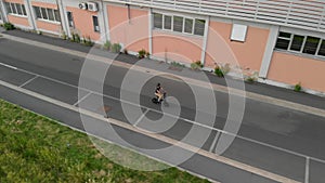 Aerial shot : Man rides his foldable electric bike on the street