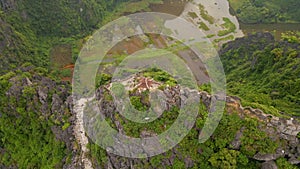 Aerial shot of man tourist by the dragon monument on the top of marble mountain, Mua Cave mountain, in Ninh Binh, a