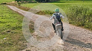 aerial shot of a motocross rider on a journey on a dirt and dusty country road driving fast and exploring beautiful