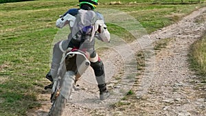 aerial shot of a motocross rider on a journey on a dirt and dusty country road driving fast and exploring beautiful