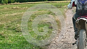 aerial shot of a motocross rider on a journey on a dirt and dusty country road driving fast and exploring beautiful