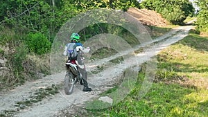 aerial shot of a motocross rider on a journey on a dirt and dusty country road driving fast and exploring beautiful