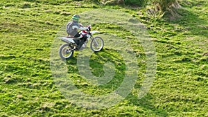 aerial shot of a motocross rider on a journey on a dirt and dusty country road driving fast and exploring beautiful