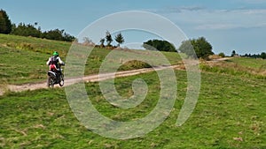 aerial shot of a motocross rider on a journey on a dirt and dusty country road driving fast and exploring beautiful