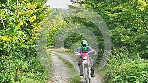 aerial shot of a motocross rider on a journey on a dirt and dusty country road driving fast and exploring beautiful