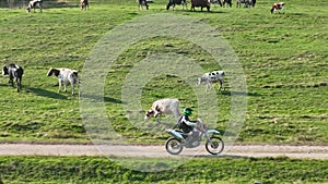 aerial shot of a motocross rider on a journey on a dirt and dusty country road driving fast and exploring beautiful