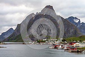 Aerial shot ofThe city of Reine in Lofoten/Norway. The famous Mount Olstind and snow covered mountains in the background.