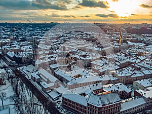 Aerial shot of Old City Lviv cowered by snow with churches and cathedrals.