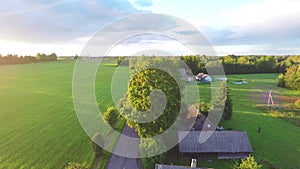 Aerial shot over lush green fields and meadows. Sunset.