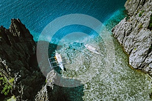 Aerial shot of the Philippines islands in Palawan. Banca boats in the morning shallow water neat to the rocks
