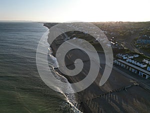 Aerial shot of a pristine beach, with several houses dotting the shoreline