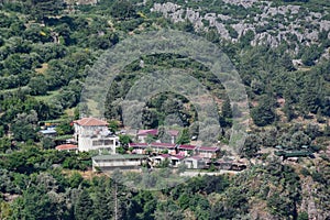 Aerial shot of pure houses and green-covered hills of the George House, Faralya, Turkey
