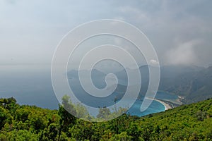 Aerial shot of pure water and green-covered hills of the Blue Lagoon in Oludeniz, Turkey