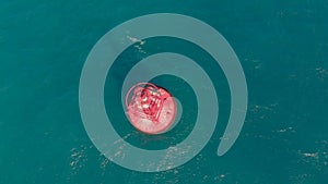 Aerial shot of a red buoy in a beautiful blue sea