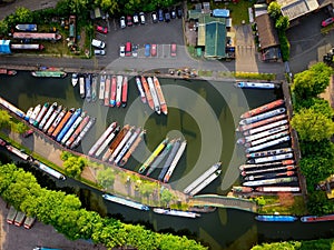 Aerial shot of a river with long cargo ships with buildings and roads by the side