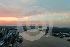 aerial shot of riverwalk along the Savannah River at sunset with hotels, restaurants, shops, Savannah City Hall