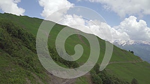 Aerial shot of road under the hill with walkers