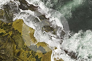 Aerial shot of rock ledge and crashing waves