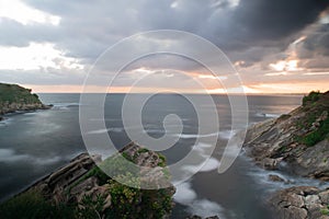 Aerial shot of rocky beach and tranquil lake under thunderhead sky