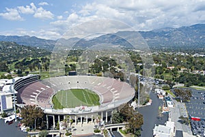 aerial shot of the Rose Bowl Stadium with lush green trees, plants and grass, homes and majestic mountains in Pasadena California photo