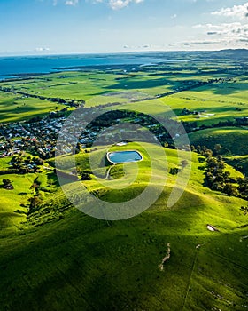 Aerial shot of a rural landscape featuring a lake and green fields. Toora, Victoria, Australia.