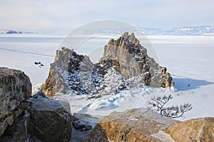 Aerial shot of Shamanka rock on Olkhon island in winter. Frozen lake Baikal in daylight, Siberia, Russia. Drone flies above