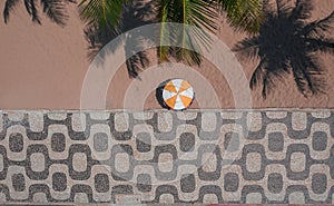 Aerial shot of a sidewalk with Copacabana mosaic next to the beach in Rio de Janeiro