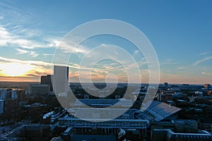 Aerial shot of skyscrapers, office buildings, apartments, and bare winter trees with cars driving on the freeway