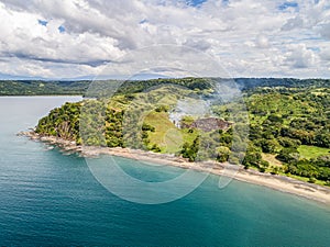 Aerial shot of small fire at the tropical coastline by Playa Arenillas in Costa Rica peninsula Papagayo coast guanacaste