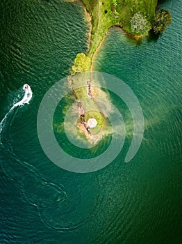 Aerial shot of a small island, with a jet ski nearby.