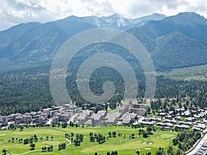 Aerial shot of a small town with residential builidings before the high mountains