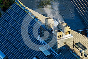 Aerial shot of a smoking chimney of a house.