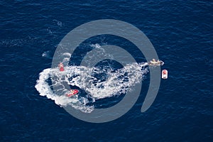 Aerial shot of some motorboats circling the sea