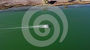 Aerial shot of speed boat motoring up river