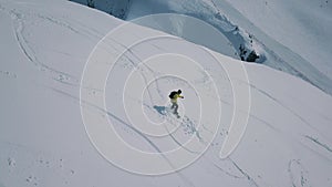 Aerial shot sports man wearing snowboarding equipment ride on track at ski resort surrounded by snow