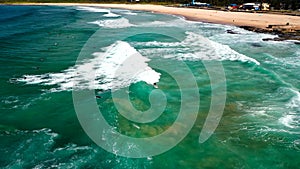 Aerial shot of surfers enjoying the waves at Maroubra Beach in New South Wales, Sydney, Australia