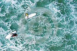 Aerial shot from surfers going to surf in the ocean