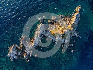 Aerial shot Sveta Nedjelja island in an open sea with a rocky and forested beach background