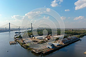 aerial shot of the Talmadge Memorial Bridge over the blue waters of the Savannah River surrounded by lush green tree