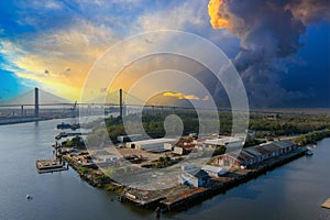 aerial shot of the Talmadge Memorial Bridge over the blue waters of the Savannah River surrounded by lush green trees