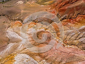Aerial shot of the textured yellow nad red mountains resembling the surface of Mars