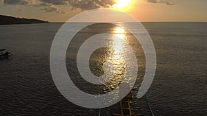 Aerial shot of three fisherman`s boats in a sea at sunset time. Drone moves backwards and reveals boats