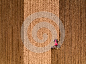 Aerial shot of a tractor cultivating field at spring