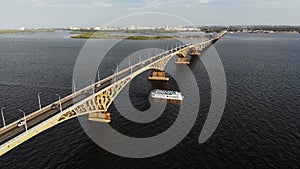 Aerial shot on the traffic on the bridge with ship going down the river