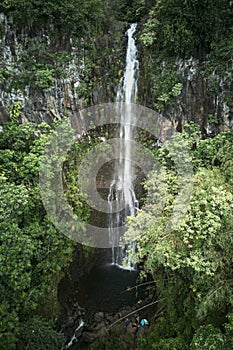 Aerial shot of a tranquil waterfall cascading down a rocky mountain terrain. photo
