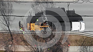 Aerial shot of Tree cutting services worker loading cut tree branches into the wood chipper machine for shredding