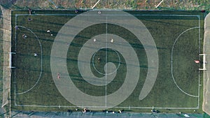 Aerial shot Two teams playing ball in football outdoors, top view. Football game outdoors, green field with markings